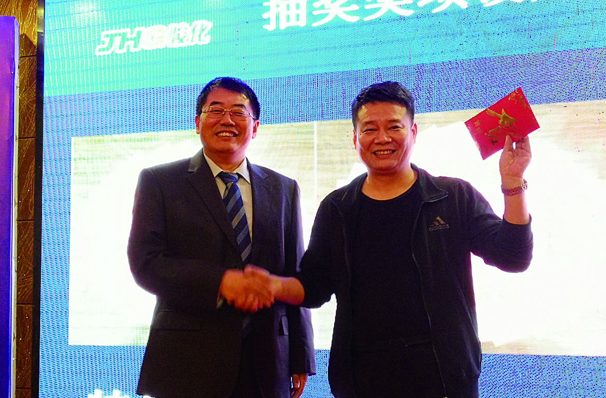 精英客户营销峰会上，昊华骏化集团总经理甘世杰（左）为优秀经销商颁发现金奖励。